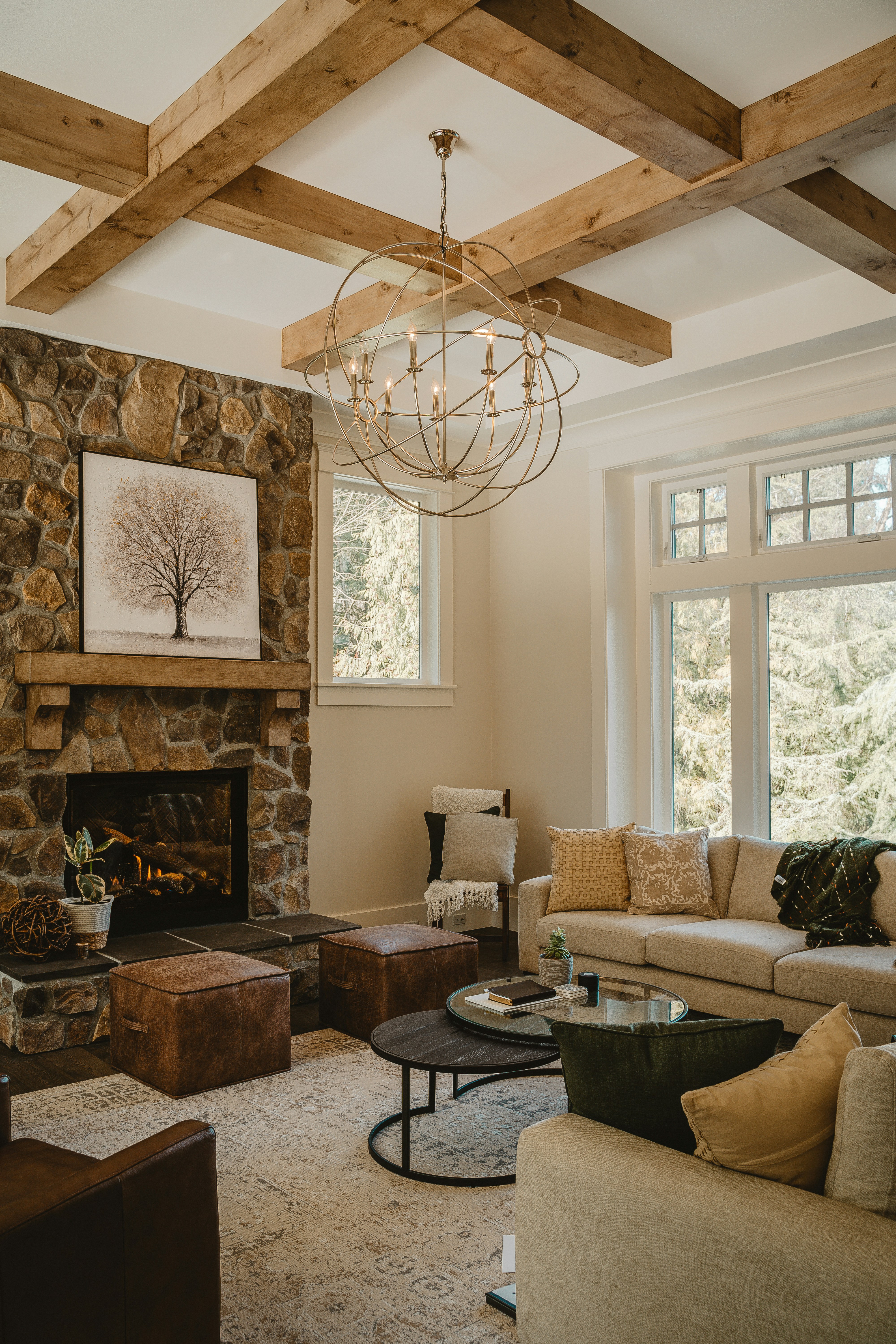 Beautifully staged living room with stone fireplace and wood beam ceiling