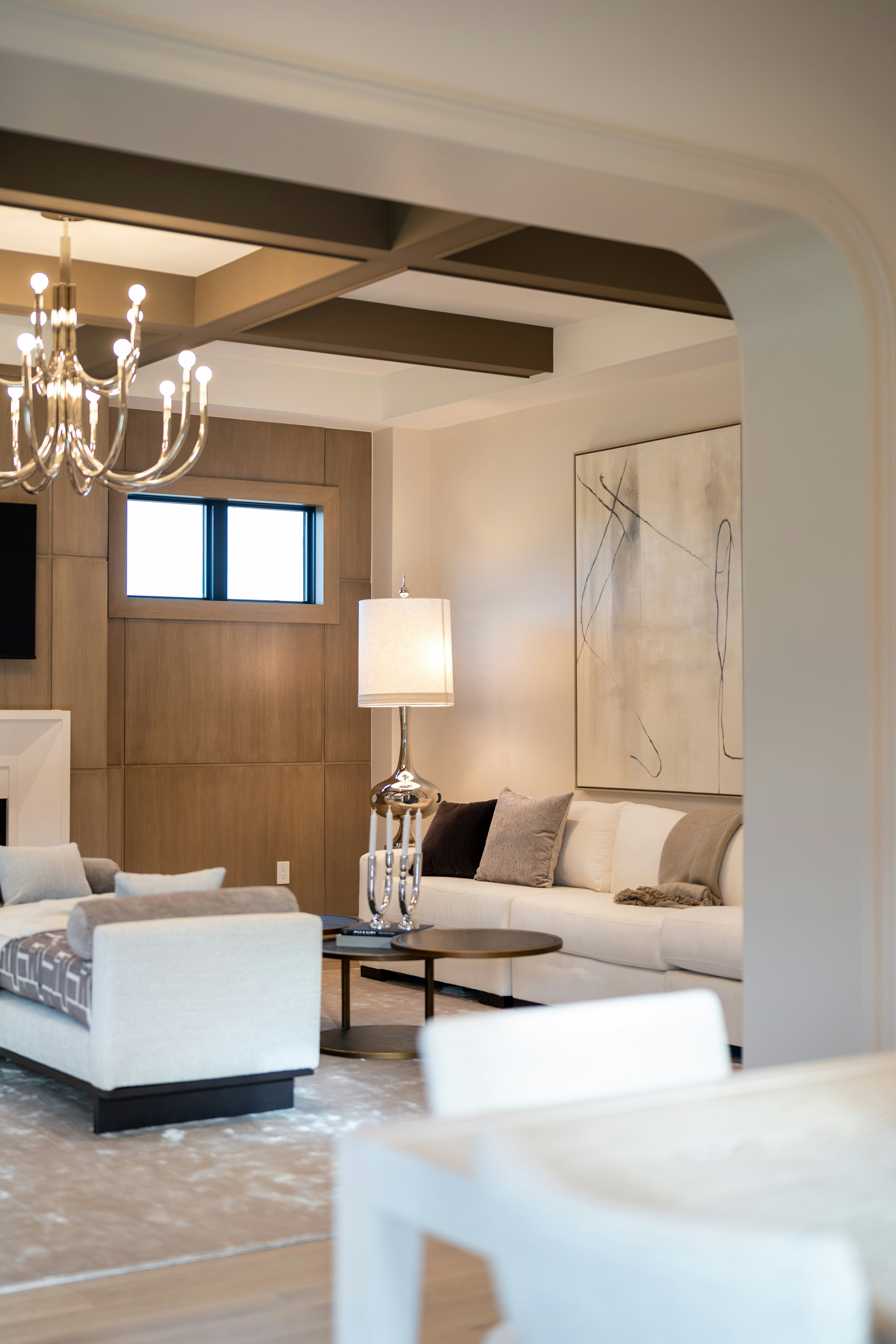Staged formal living room with archway and abstract art