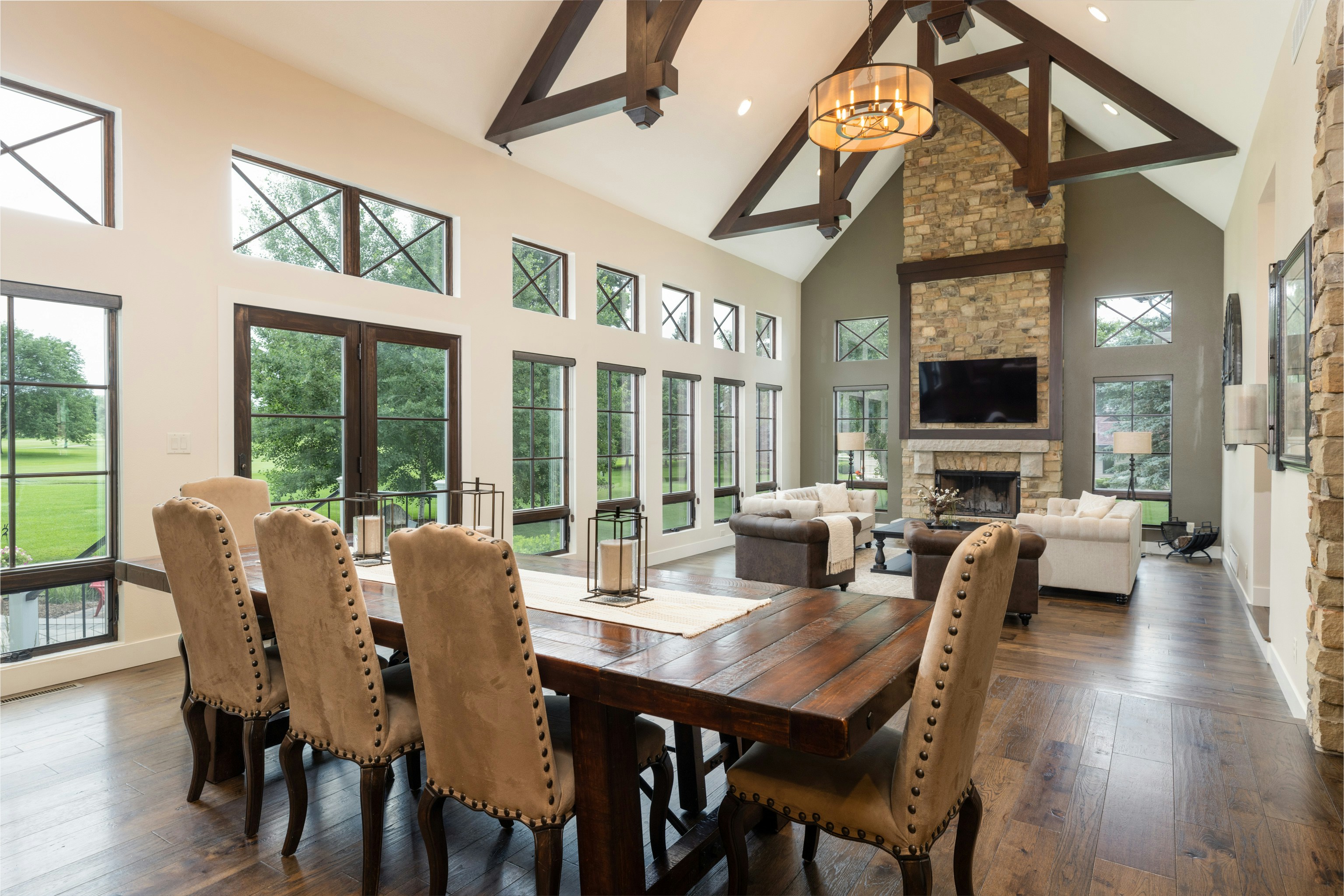 Staged great room with vaulted ceilings, exposed beams, and fireplace